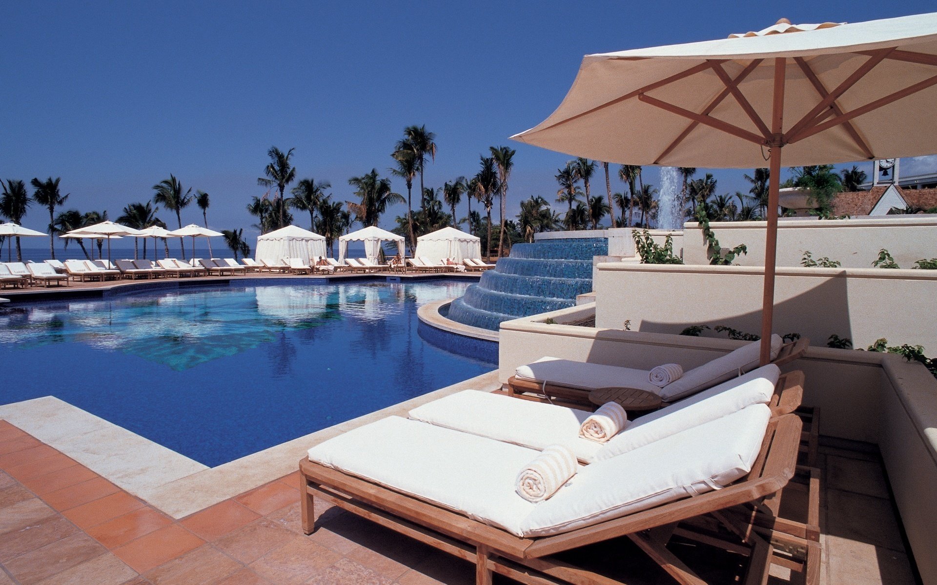 ciel bleu transats parasols piscine eau ciel station balnéaire loisirs chaises longues palmiers tropiques fontaine hôtel été chaleur ciel bleu chaleur