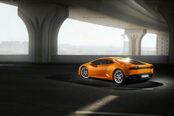Une lamborgini orange se trouve sur le parking