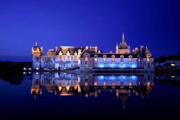 Merveilleux reflet du château de nuit dans le rétro-éclairage