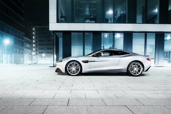Voiture Aston Martin au milieu de la ville de nuit
