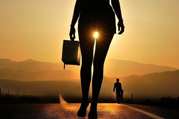 Silhouette d une jeune fille avec une valise au coucher du soleil