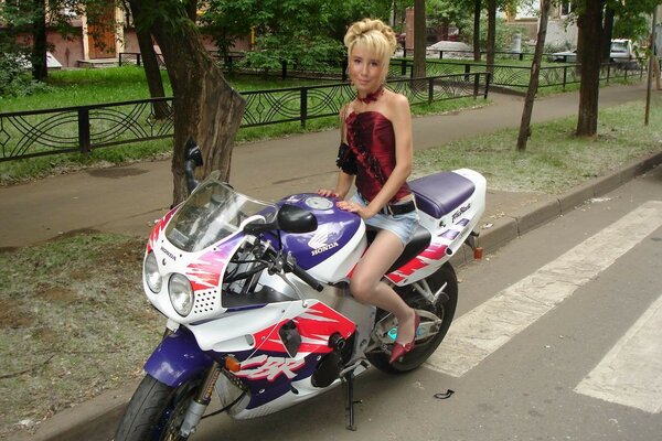 Femme en minijupe sur une moto sur la route