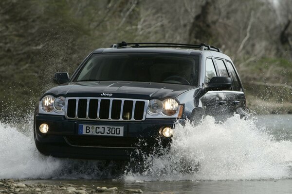 Jeep Monte en toute confiance sur la rivière dans les montagnes