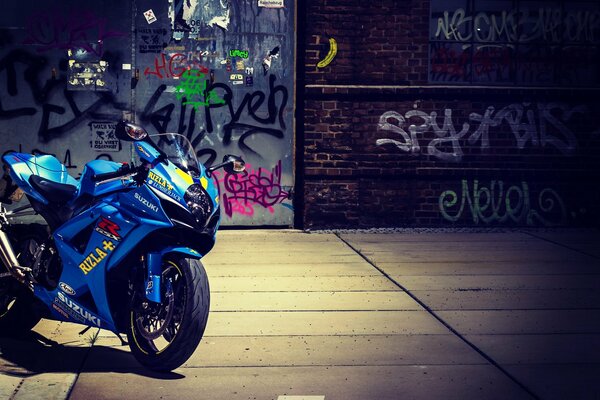 Moto bleue garée derrière le graffiti