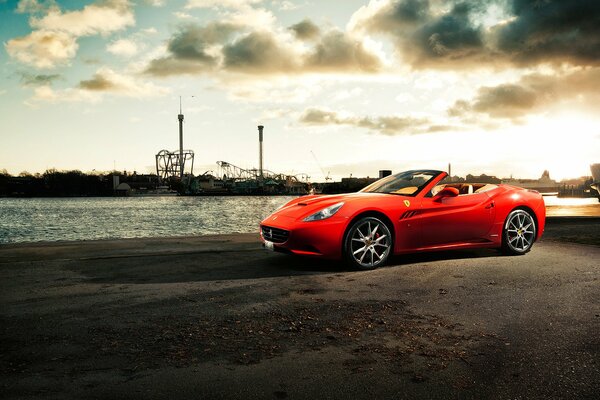 Une voiture Ferrari California sur une jetée au bord de la rivière