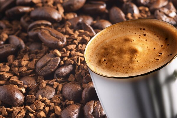 Tasse de café avec de la mousse sur les grains