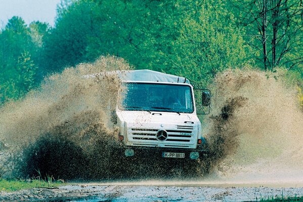 Le camion à grande vitesse traverse une flaque d eau. éclaboussures