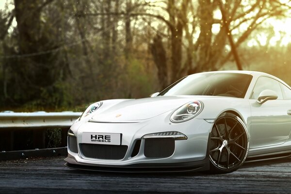 Porsche blanc sur fond de forêt