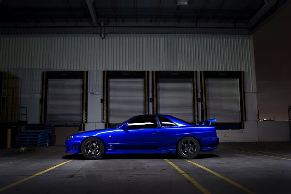 Voiture Nissan R34 bleu debout dans l obscurité dans la rue