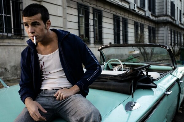 L acteur Mario Casas est assis et fume en voiture