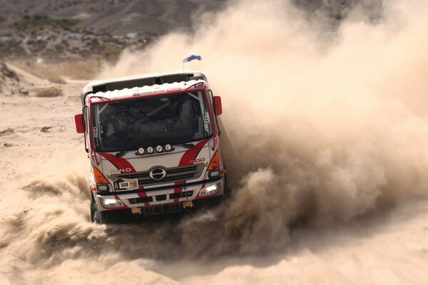 Camion de sport poussière sur la piste sur le sable