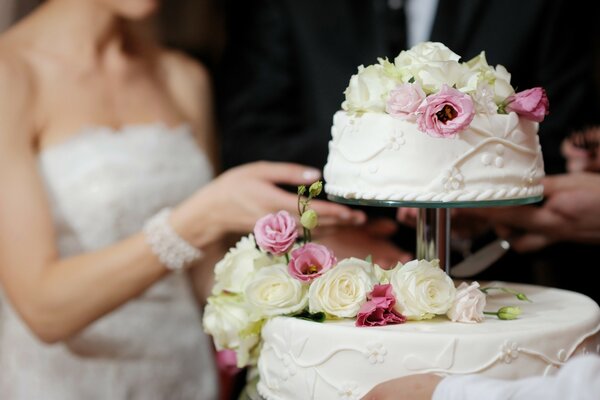 Gâteau de mariage avec des roses sur fond flou