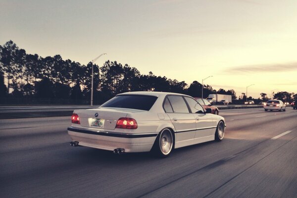 Blanc BMW E38 course à la vitesse sur l autoroute