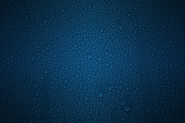 Gouttes transparentes bleues sur le verre