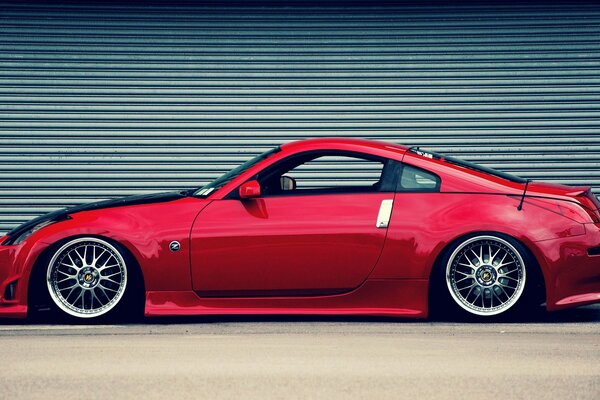 Photo d une nissan 350Z rouge sur fond de rouleau fermé