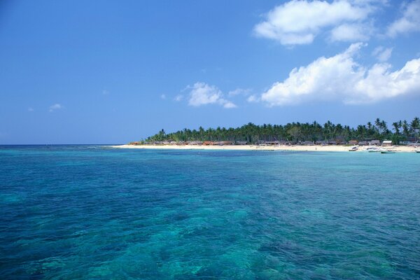 Mer turquoise baignant la plage avec des huttes