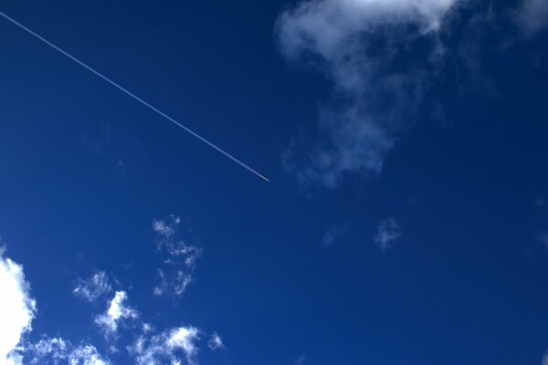 Trace d un avion dans le ciel bleu parmi les nuages