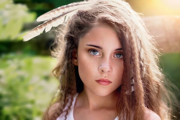 Fille avec des plumes sur la tête et les cheveux bouclés