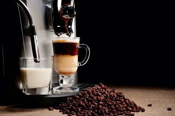 Café et lait dans la machine à café sur fond noir