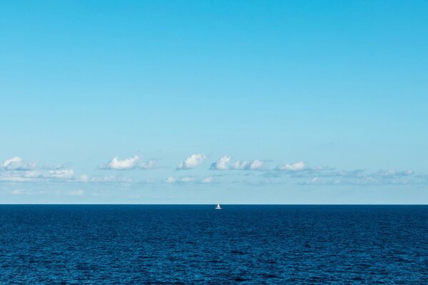 Voile blanche solitaire dans le brouillard bleu de la mer