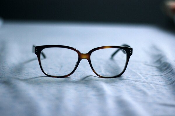 Lunettes à monture sombre sur tissu clair