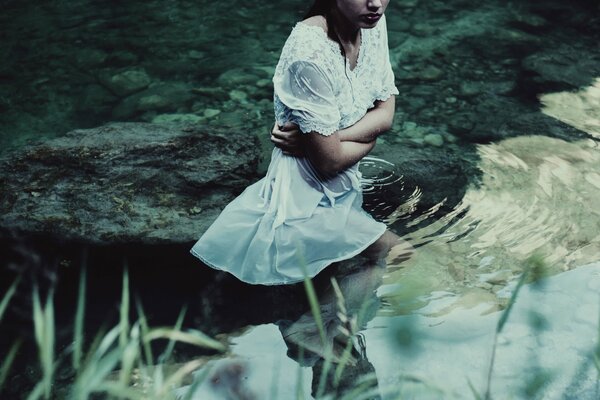 Photoshoot dans l eau calme, fille en robe blanche
