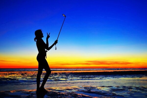 Coucher de soleil sur la mer. Fille. Selfie