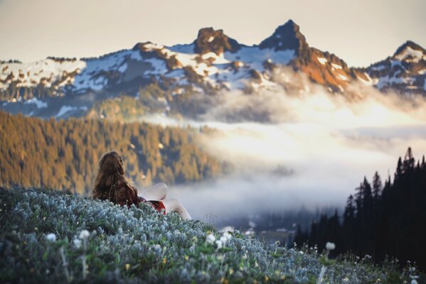 La jeune fille observe les montagnes enneigées