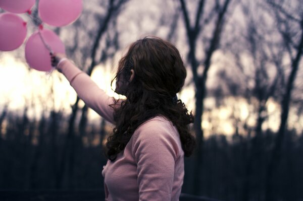 Fille tenant des ballons de couleur rose à l arrière-plan flou