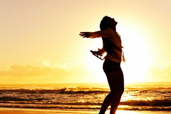 Silhouette d une jeune fille joyeuse sur fond de coucher de soleil de mer