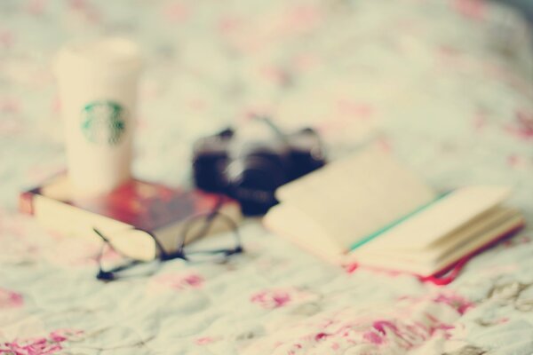 Sur la table se trouve un livre de lunettes et un verre