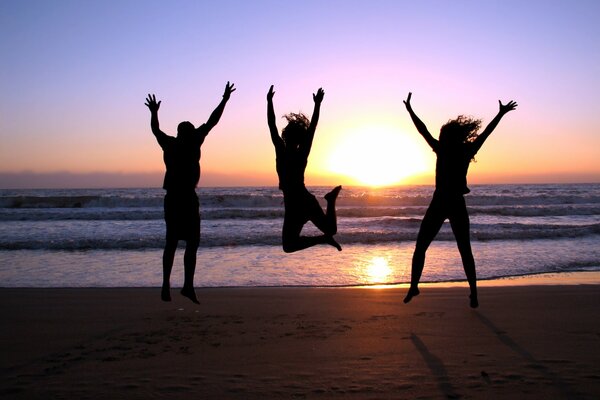 Trois filles prenant des photos au coucher du soleil