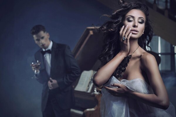 Femme sexy et homme debout près du piano