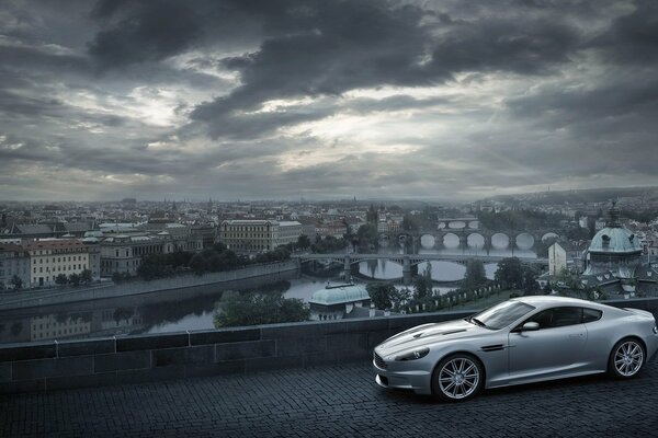 Aston Martin sur fond de ville avec des nuages
