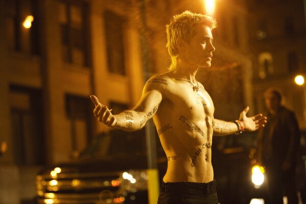 Jared Leto avec torse nu sur fond de bâtiment