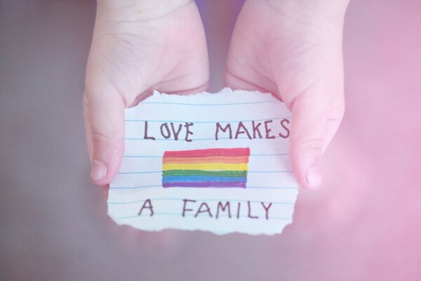 Dessin d un arc-en-ciel sur un morceau de papier avec une inscription dans les mains d un enfant