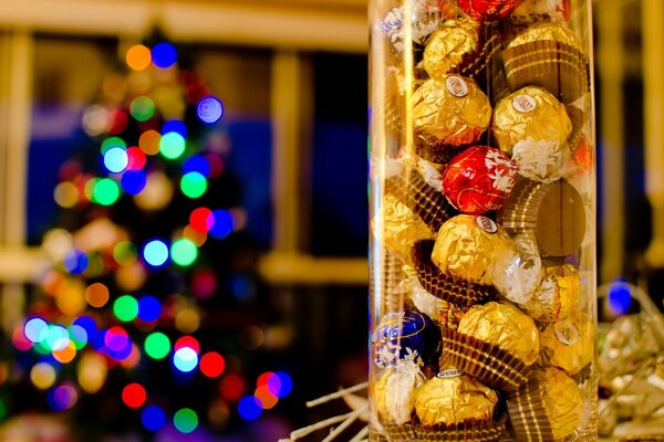 Pot de bonbons au premier plan et arbre de Noël décoré à l arrière