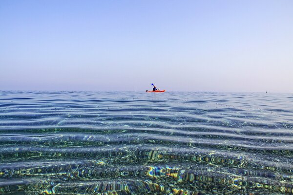 Homme en canoë nage dans la mer