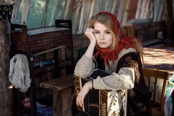 Triste fille dans un foulard avec un accordéon