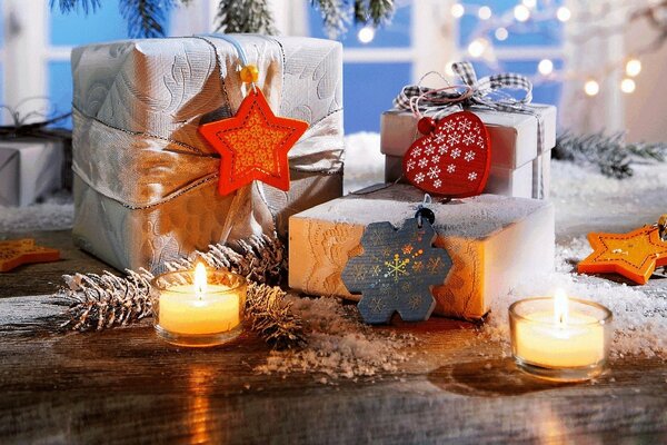 Cadeaux de Noël entourés de bougies et de cônes de sapin