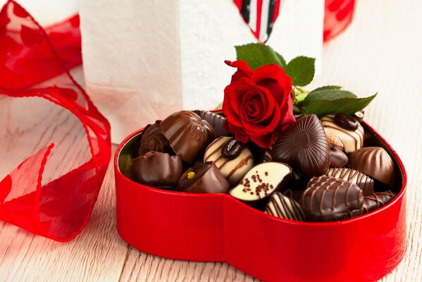 Boîte rouge avec des bonbons au chocolat et rose