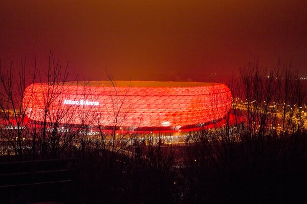 Stade lumineux dans la nuit. Rétro-éclairage rouge