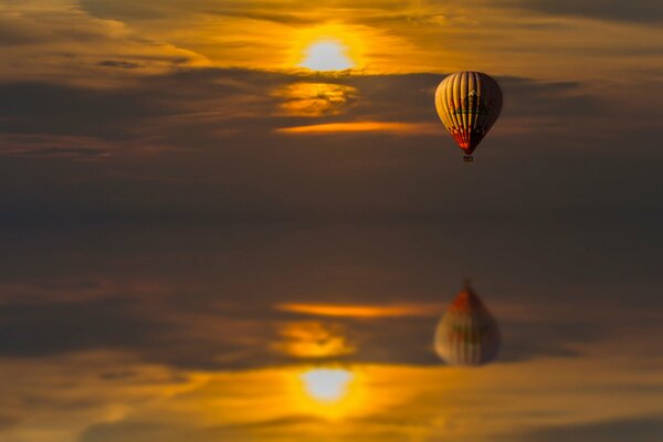 Reflet dans l eau d un ballon volant au coucher du soleil