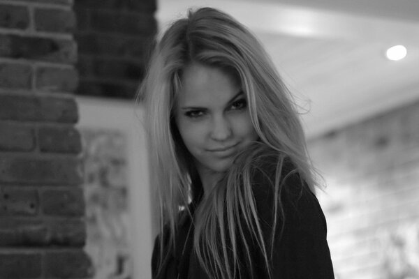 Photo en noir et blanc du modèle Emily Marie. Sur la photo, la fille a plissé les yeux