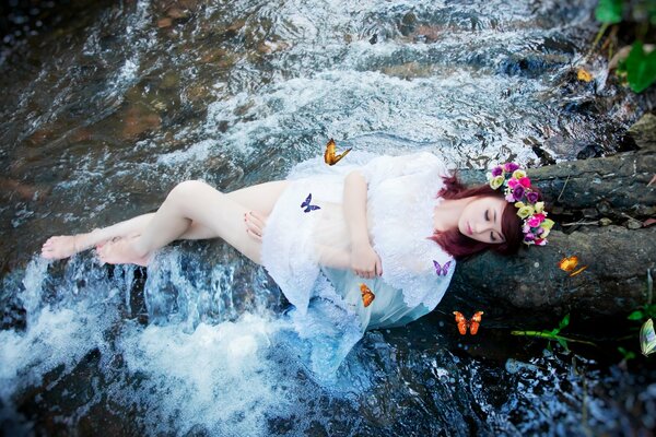 Fille avec des papillons près de la rivière