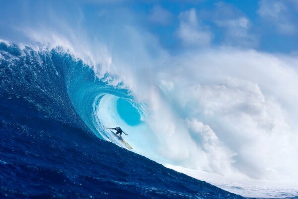 Un surfeur passe sous la grande vague