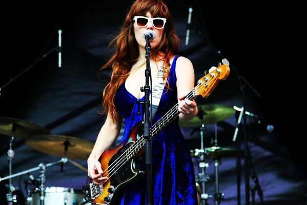 La célèbre chanteuse Jenny Lewis debout sur scène et jouant de la guitare