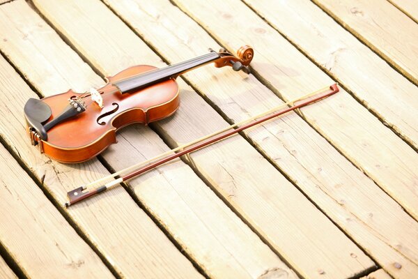 Violon et arc se trouvent sur le plancher en bois