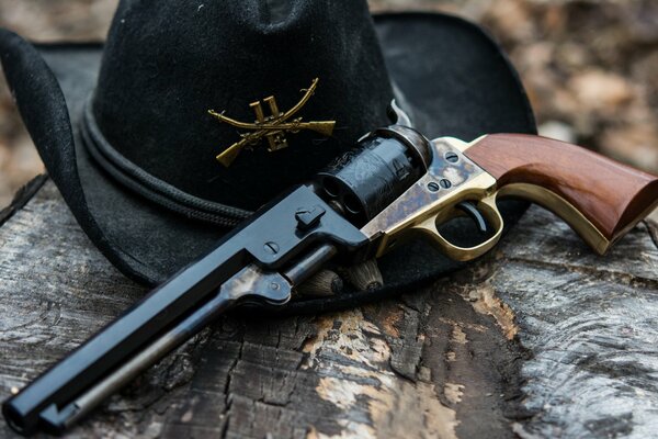 Chapeau noir et revolver se trouvent sur l écorce d un arbre
