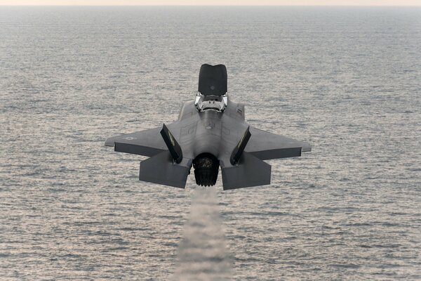 Bombardier de chasse décolle au-dessus de la mer